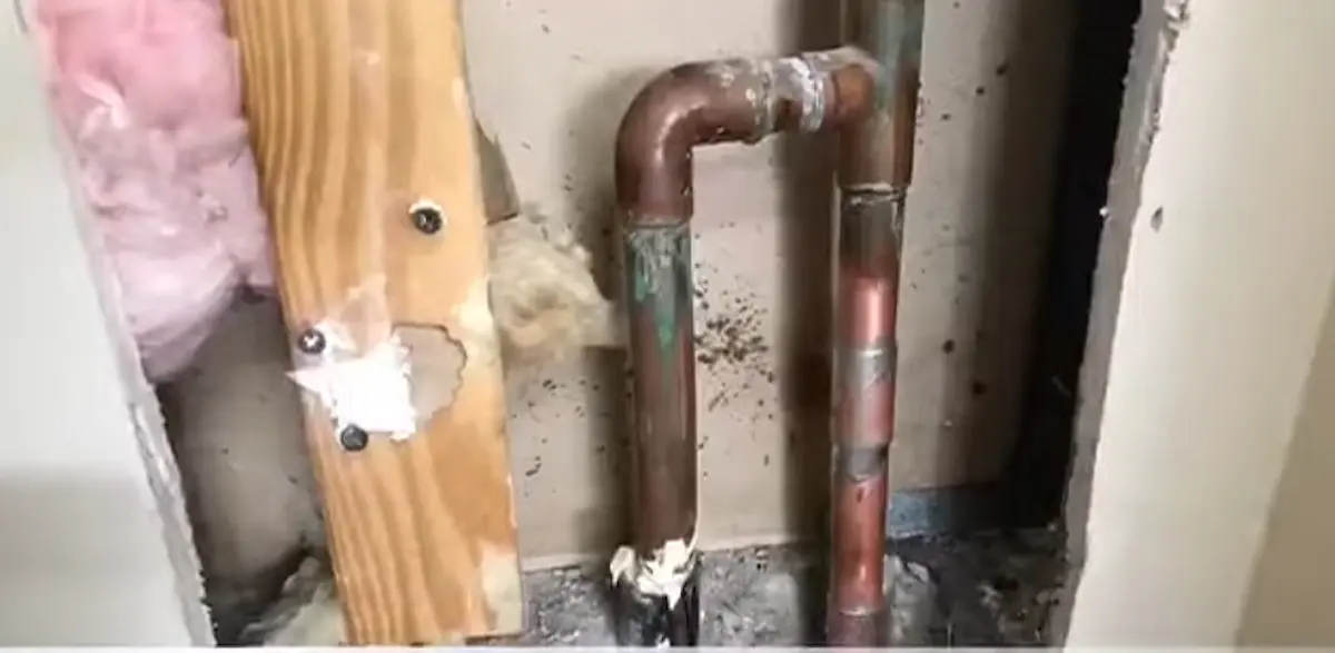 Copper pipe fitting exposed inside a wall during leak detection in a Palm Springs home